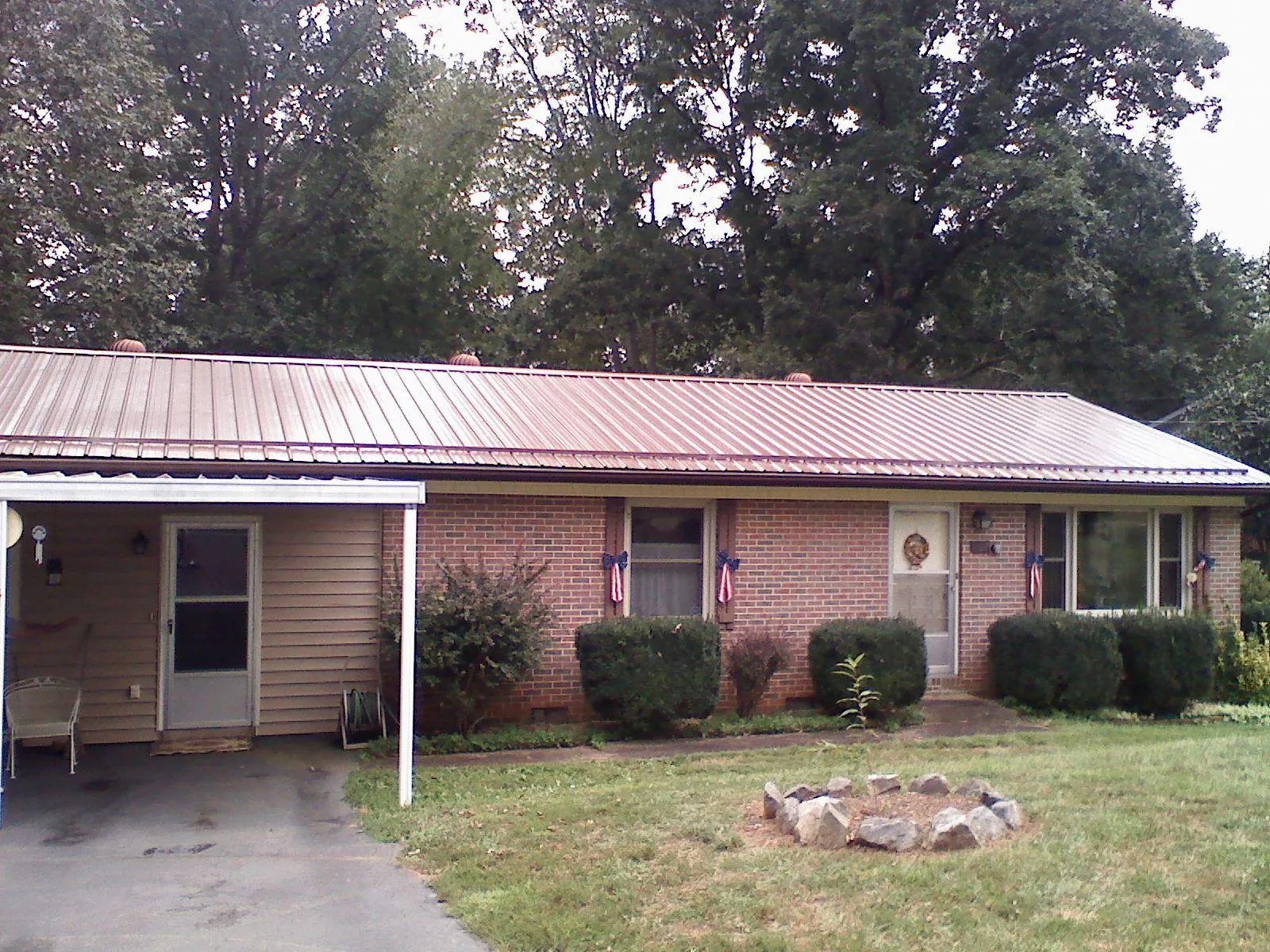 Bronze metal roof and carport on a brick ranch home — Roof Repair work by our crew in Moss Landing